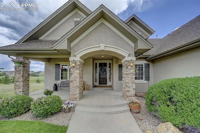 Property entrance featuring stucco siding, a shingled roof, and stone siding