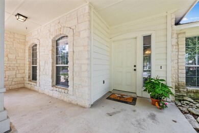Property entrance with stone siding and covered p