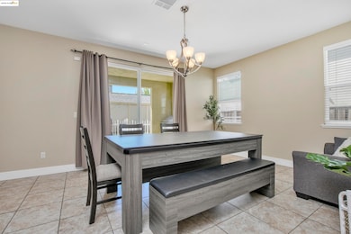 Dining area with a chandelier and light tile patterned flooring