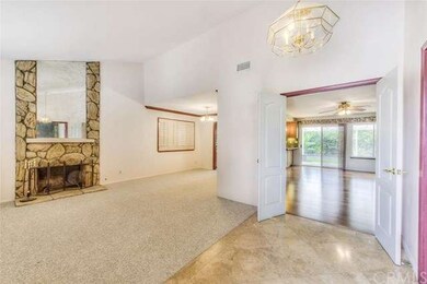 Travertine flooring in the entry way and Berber carpeting in the living room and dining room.  Through the double doors leads you into the spacious family room with hardwood floors.