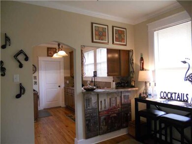 Breakfast room has bar that opens to kitchen .