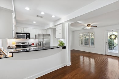 Kitchen with dark wood-type flooring, white cabine