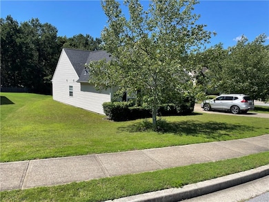 View of property exterior featuring a spacious level lot great for kids to play.