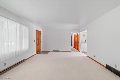 Carpeted spare room with baseboard heating