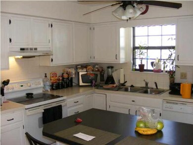 The kitchen has an eating bar with an island
