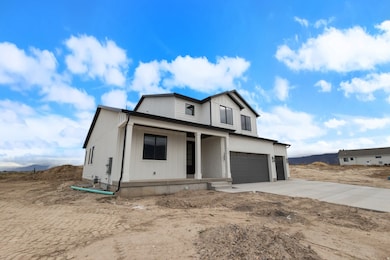 Modern farmhouse featuring covered porch, an attached garage, and driveway