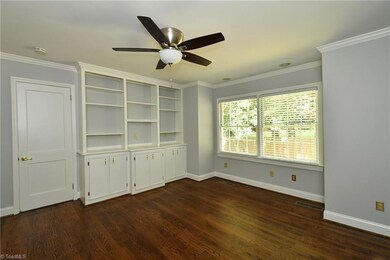 Master bedroom with built-ins and door to sunroom.