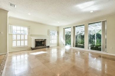 LIVING AREA-This room features walls of windows, stone floors and a gas log fireplace with granite surround.