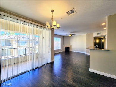 Kitchen with freestanding refrigerator, dark wood-style floors, a ceiling fan, brown cabinets, and recessed lighting