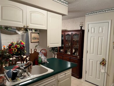 Kitchen with sink, white cabinets, and a textured 