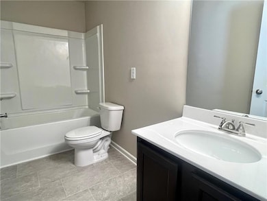 Bathroom featuring toilet, vanity, baseboards, and