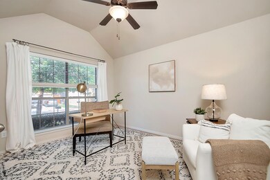Office with lofted ceiling, light colored carpet, 