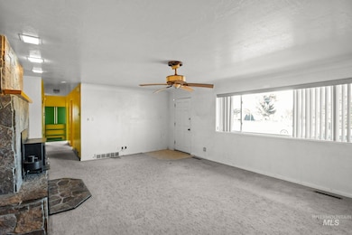 Unfurnished living room featuring carpet and ceiling fan