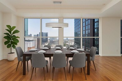 Dining room with a city view, plenty of natural light, light wood finished floors, and expansive windows