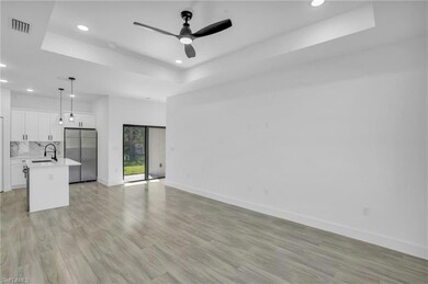Unfurnished living room with a tray ceiling, light