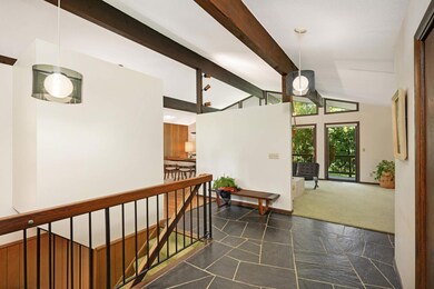 The main level open concept showcases beautiful vaulted ceilings adorned with wooden beams.