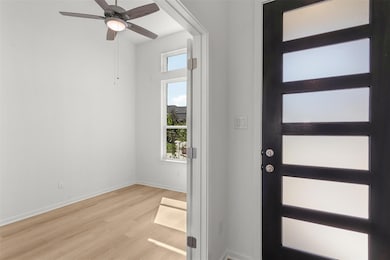 Foyer featuring light wood-style floors and ceiling fan
