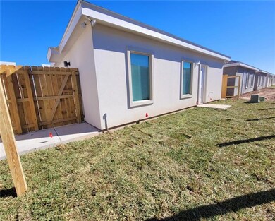 Rear view of property with stucco siding and a gate