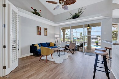 Living room featuring a sunroom, high vaulted ceiling, light wood-style floors, and a ceiling fan