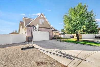 View of front facade featuring concrete driveway, stone siding, a garage, and a gate