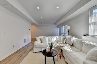 Living area with light wood-style flooring, visibl