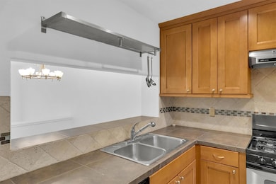 Kitchen with under cabinet range hood, gas stove,