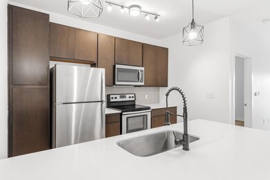 Kitchen with light countertops, backsplash, appliances with stainless steel finishes, and a sink