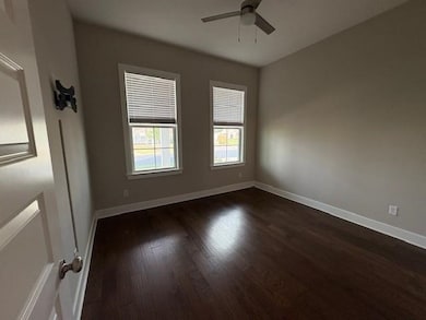 Spare room with a ceiling fan and dark wood-style floors
