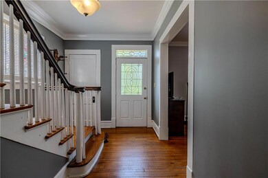 Entryway with stairway, hardwood / wood-style floors, and ornamental molding