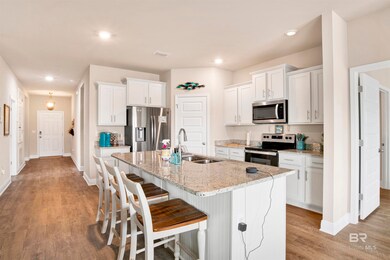 Kitchen featuring a kitchen island with sink, a breakfast bar, appliances with stainless steel finishes, light hardwood / wood-style floors, and sink