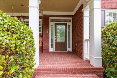 View of front porch entry featuring brick facade a