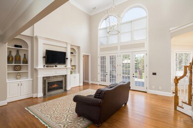 The soaring two story family room boasts fresh paint, gas fireplace flanked by built ins, elegant mantel, and large wall of windows overlooking the amazing back yard.