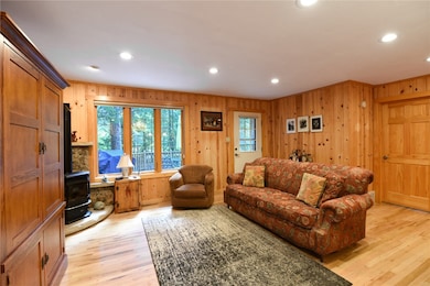Living room featuring a wood stove, light wood-sty