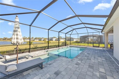 View of pool featuring a patio, a water view, a residential view, a pool with connected hot tub, and a lawn