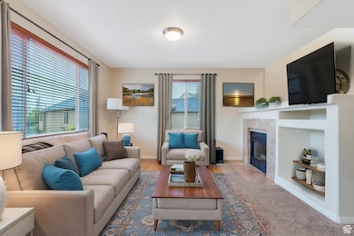Living room featuring a tile fireplace, baseboards, and wood finished floors
