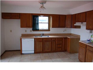 KITCHEN WITH TILE FLOORS AND EATING AREA.