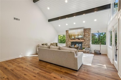 Living room featuring hardwood / wood-style floors, high vaulted ceiling, and plenty of natural light