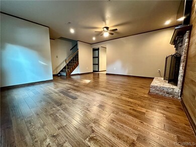 Living room with a fireplace, wood floors, and cei
