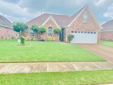 Traditional-style home featuring a front lawn, brick siding, driveway, roof with shingles, and a garage
