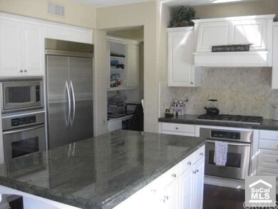 Spacious Kitchen with Custom Granite and Stainless