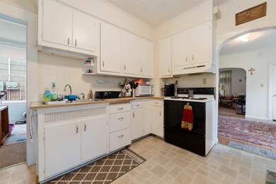 Kitchen with white appliances, white cabinetry, an
