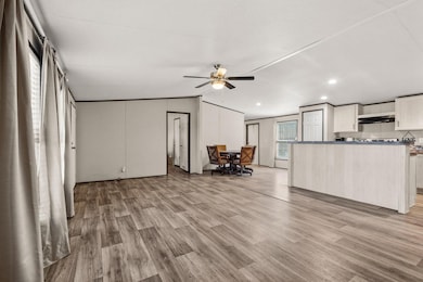 Living area with light wood finished floors, vaulted ceiling, a ceiling fan, and recessed lighting