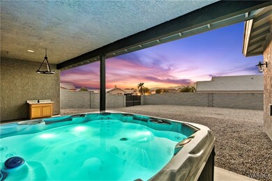 Pool at dusk featuring a hot tub