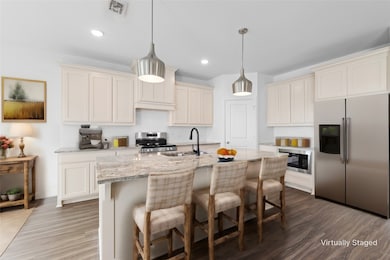 Kitchen with decorative backsplash, appliances with stainless steel finishes, a breakfast bar, light stone counters, and recessed lighting