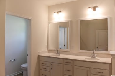 Full bathroom with double vanity and toilet