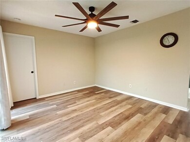 Empty room with baseboards, a ceiling fan, wood fi