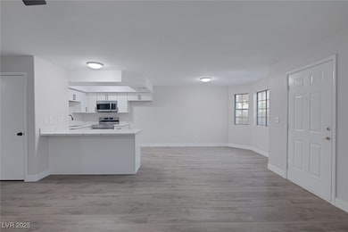 Kitchen featuring a peninsula, appliances with sta