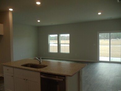 Kitchen with light stone counters, recessed lighti