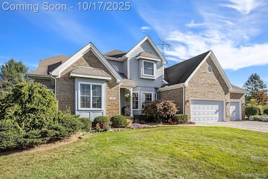 View of front facade with a front lawn, brick siding, roof with shingles, and driveway