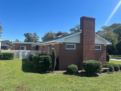 View of property exterior with a chimney and brick siding
